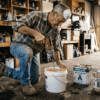 Man mixing epoxy resin on garage floor
