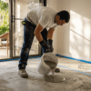 Technician applying epoxy in bright living room