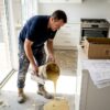 Contractor pouring resin on kitchen floor